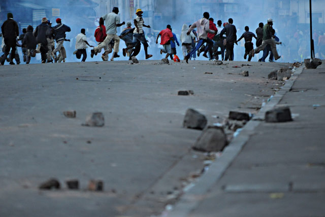 © Walter Astrada / Agence France-Presse # 033 Partisans d'Andry Rajoelina, maire d'Antananarivo, fuyant les tirs de gaz lacrymogène, après une confrontation entre manifestants et forces de l'ordre. 16 février 2009.
